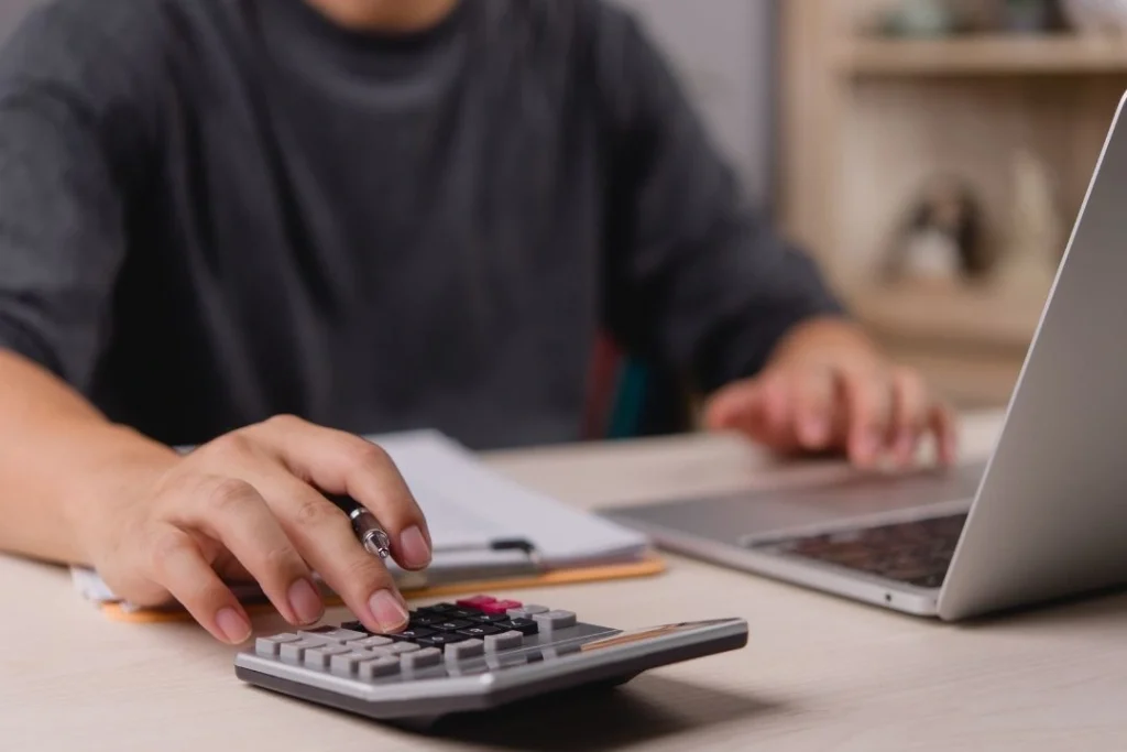 man using calculator to budget